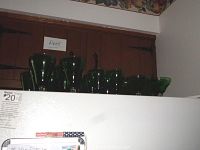 Photo showing several green glassware pieces lined up on a white surface, highlighting the green bowls and clear stems.