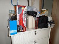 Overall photo of lot showing Catch Caddy box, travel bags, mini tool set, and other items on a white cabinet.
