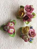 Three bone china floral brooches arranged on flat surface, showing colorful detailed flowers and glossy finish.
