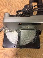 Top view of mitre saw showing base protractor and pivot for angle adjustment, metallic silver and black construction.