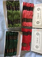 Four boxes with approximately 70 skeins of Dollfus Mieg & Co DMC embroidery thread in green and pink hues, still in original boxes.