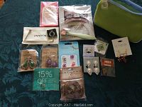 Full view of all jewelry items arranged on table, including earrings, charms, bracelet, and green fabric bag