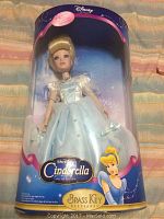 Full view of boxed Disney Cinderella porcelain collector doll showing detailed packaging with artwork and branding.