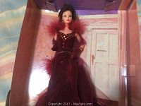 Scarlett O'Hara Barbie doll dressed in burgundy gown with tulle skirt and feather accents inside display box.