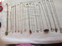 Top view of all 15 necklaces laid out in rows showing pendants and chain styles.