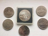 Seven Canadian silver dollar coins dated 1968, 1969, 1981, 1984, 1986 (two coins from 1986), one in a protective case.