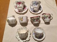 Top view of cups and saucers showing different floral patterns and delicate design details on multiple fine china pieces.