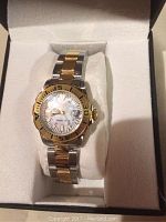 Invicta two-tone divers watch with gold bezel and stainless steel band displayed in a cushioned box.
