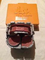 Photo showing the orange Fisher Price Tool Kit case with molded tool designs on lid and the front of the play castle with wood-textured floors.