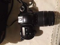 Top view of Canon EOS 3000 camera with attached zoom lens showing camera dials and controls.