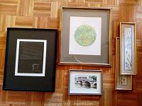Framed art prints arranged on wooden floor showing all five prints including two Asian vertical prints and three horizontal prints, various frame styles and sizes.