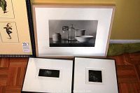 Group photo showing one large still life print and two smaller framed prints on floor near wall.