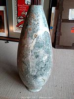 Front view of tall teardrop-shaped marble vase