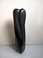 Front-left angled view of black art glass vase showing organic elongated lobes.