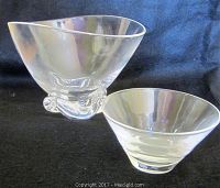 Two clear glass bowls by Steuben shown side by side on a black background, highlighting the size difference and design.
