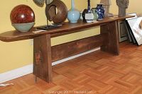 Front and side view of the handcrafted wooden bench showing solid wood construction, warm brown stain, and angled legs with horizontal support beam.