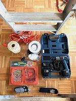 Photo of 5-foot aluminum ladder and various tools laid out, including a Ryobi cordless drill and black hardware items