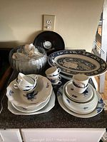 Overall view of punch bowl, cups, plates, and platters on countertop