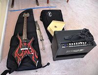 Overview of all items: B.C. Rich guitar in gig bag, Pearl xylophone in case, folded music stand, triangular harp, Kustom amp with cable