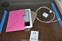 White Nook eReader in pink case, showing power off screen, with charger and USB cable beside it on brown surface.