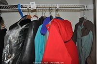 View of assorted jackets hanging on a rack in various colors including red, blue, gray.