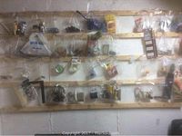 View of wooden slats with multiple clear plastic bags containing various hardware items such as knobs, washers, and extension cords