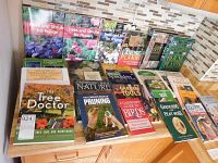 Books displayed on wooden counter showing titles related to trees, pruning, garden tools and general gardening knowledge.