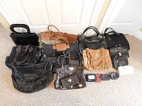 Overview of all purses and wallets included in the lot, displayed on floor showing quantity and variety.