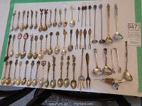 Full layout of over 40 silverplated souvenir spoons and forks, plus small ladles and utensils, all vintage pieces.