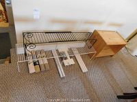 Two metal wire shelving units (one black decorative and one white expandable) with rolls of shelf liners beneath, plus adhesive white boards.