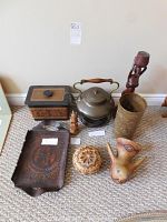 Full view of all decorative items including brass teapot and warmer, wooden statues, leather tray and ice box, gourd bowl, folk art bird, and brass candle cover.