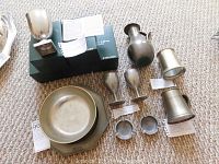 Photo showing the collection of pewter items on a carpet, including boxed goblets and assorted ware.