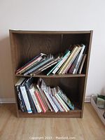 Front view of wooden bookshelf filled with assorted books.