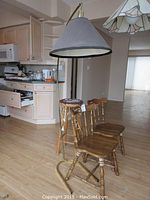 Overview showing the two kitchen chairs, wooden barstool with cushion cover, and the tall lamp on brass base with grey shade