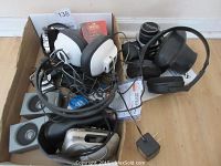 Photo showing headsets, cables, a Seiko watch, AC adaptor, and wiring tangled together in a box.
