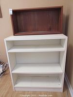 Front view of brown wood bookshelf stacked on white bookshelf showing shelves and overall condition.