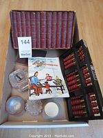 Full lot overview showing all included items: ten Shakespeare books, postcard-sized booklet, vintage abacus, glass bottles, inkwell, and other small glass items.