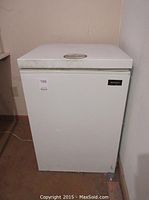 Front view of the Kenmore white deep freezer, showing the closed top lid and Kenmore brand badge.