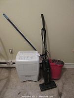 Photo showing all items in lot: Whirlpool Gold dehumidifier, Eureka vacuum, mop with blue handle, and pink bucket