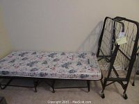 Assembled rollaway bed with mattress beside folded second frame