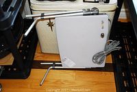 Gray rectangular bathroom scale with two metal handles and attached power cord, labeled 'dry-kold'.