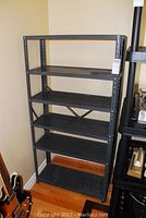Full view of the metal storage shelving unit showing all six shelves and overall structure against a wall.
