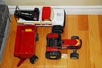 Top view of white and red Canadian Tire tow truck, red hopper truck, and red Tonka tractor with large tires