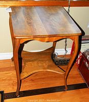 Front and top view of the vintage solid wood side table showing Queen Anne legs and scalloped edges.