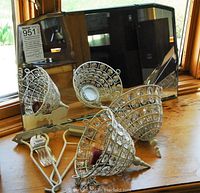 Photo showing the vintage mirror standing at the back with two hanging candle holders placed in front, highlighting the mirror's rectangular shape and thick frame and candle holders' lattice design with prisms.