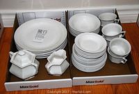 Full overview of the dinnerware set including plates, cups, cream and sugar bowl.