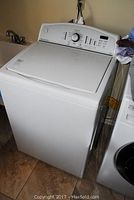 Full view of Kenmore white top-load washing machine showing machine body and lid closed.