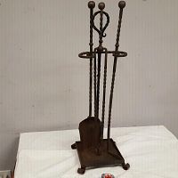 Full view of the wrought iron fireplace tool set with stand and four tools displayed upright.