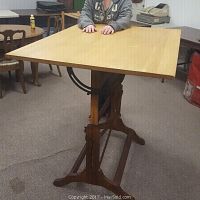 Front and top view of the drafting table showing solid maple top and oak base with cast iron adjustment arms.