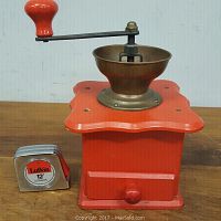 Front and side view of the copper and wood coffee grinder next to a 12' tape measure for size comparison.